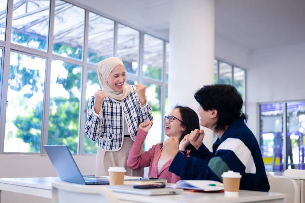 istock Group of diverse young university students preparing for exam and having study work discussion together using laptop in classroom 2149633918