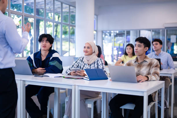 istock Lecturer talking to a group of multi ethnic young university students in the classroom 2149633998