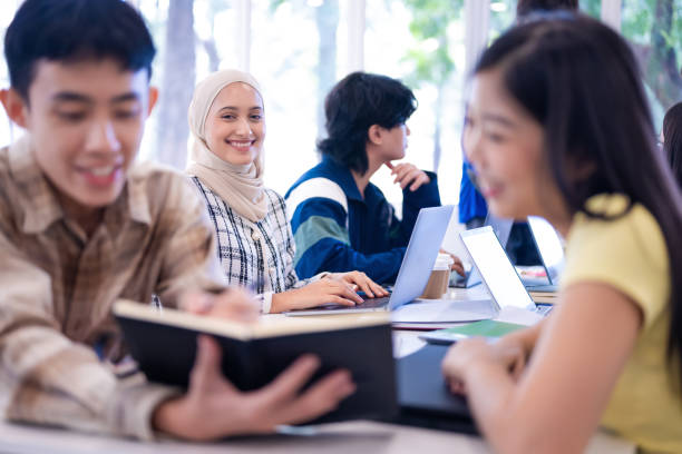 istock Young female Muslim student with hijab and her classmates learning and studying together in classroom 2149634070