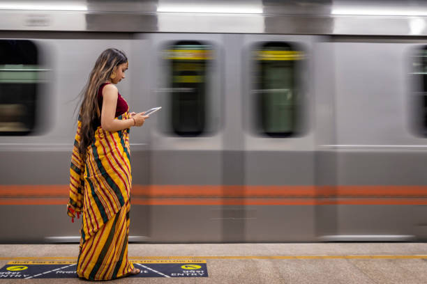 istock Indian girl using a digital tablet at metro station, India 2149634141