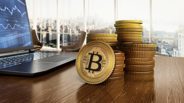 istock Stack of cryptocurrency coins standing on office table near a laptop computer with business sale chart 2149634663