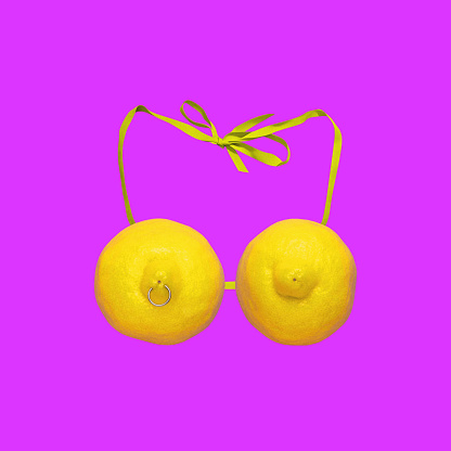 Creative image depicting lemons forming female bra, swimsuit on pink background. Summer vibe. Contemporary art collage. Concept of surrealism, pop art, creativity, imagination, party, fashion