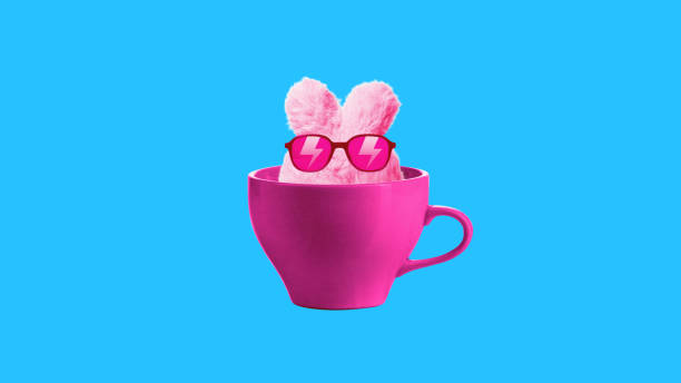 istock Pink bunny rabbit wearing sunglasses sitting inside cup on blue background. Contemporary art collage. Toy, accessories store, entertainment. 2149635358