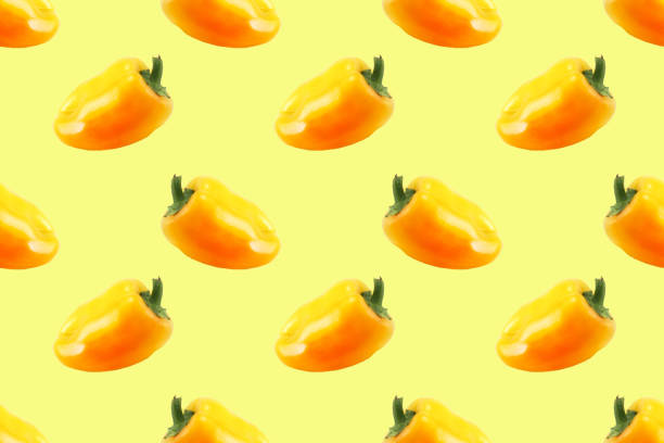 istock Pattern of ripe yellow bell peppers on a yellow background 2149636563