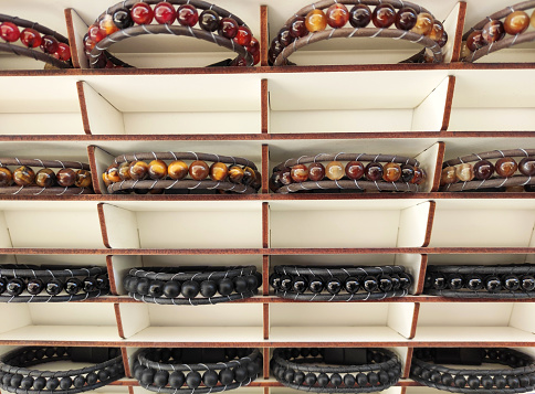 Beautiful bracelets on the hand made of colorful round beads on the shop a window