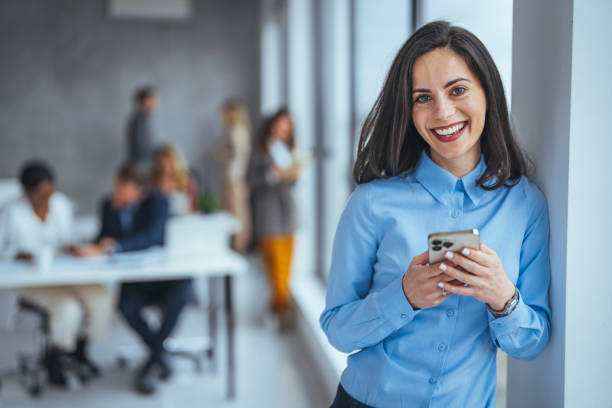 istock Casually dressed young woman using her mobile phone to read something at work. 2149638622