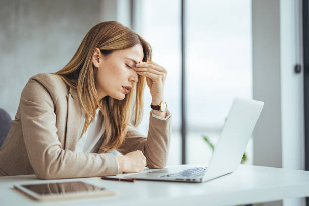 istock Exhausted businesswoman having a headache in modern office 2149639027