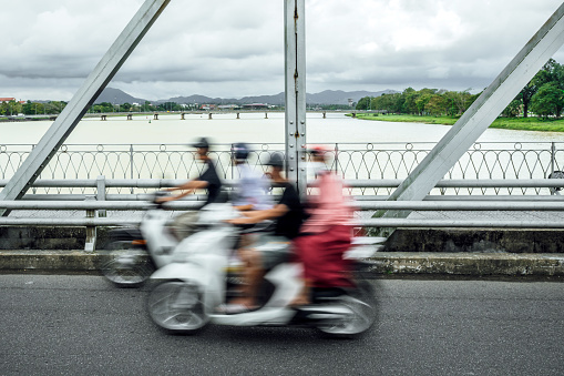 motion blurred motor scooters on Truong Tien bridge in Hue, Vietnam