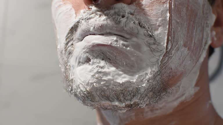 Shaving thick stubble with a disposable shaving machine. Close-up of shaving.