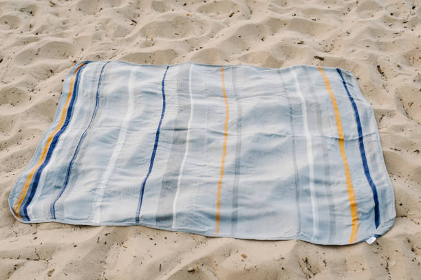 istock Blanket top view. Preparing for date picnic. Spreading blanket for picnic on sand sea on seashore. Plaid on beach ocean for enjoying summer day. 2149640701