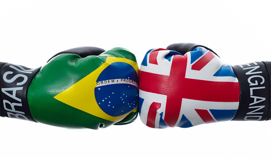 UK flag and Brazilian flag on boxing gloves.