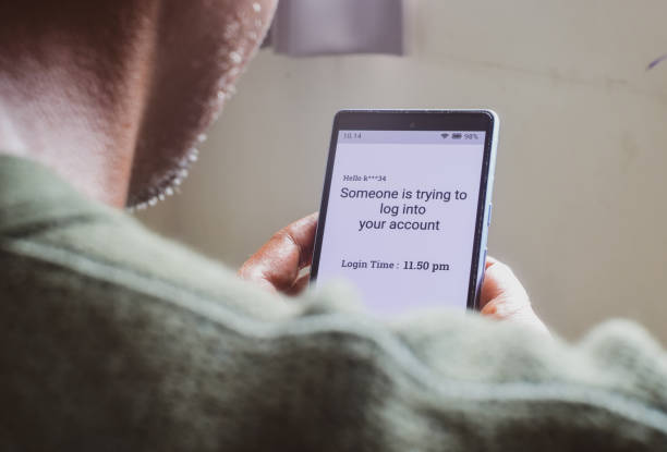 istock Man checking smartphone message saying someone trying to log into your account. Screen hacking, phishing concept, selective focus. 2149644303