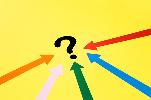 Choice concept with arrows focusing on question mark on yellow background