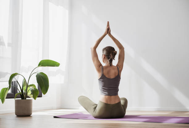 istock Woman doing relaxation exercises, practicing yoga, meditating at home 2149645343