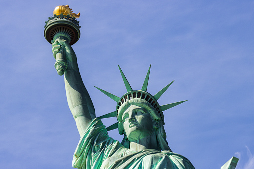 Close-up of the head and crown of the Statue of Liberty with deep blue sky copy space