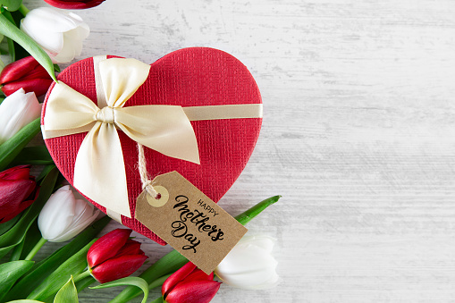 Mother’s Day concept with red and white tulips and heart shaped gift box