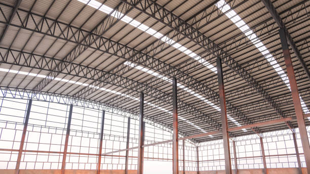 istock Steel wall framework structure with metal columns and curve roof beams inside of large industrial factory building in construction site 2149648567