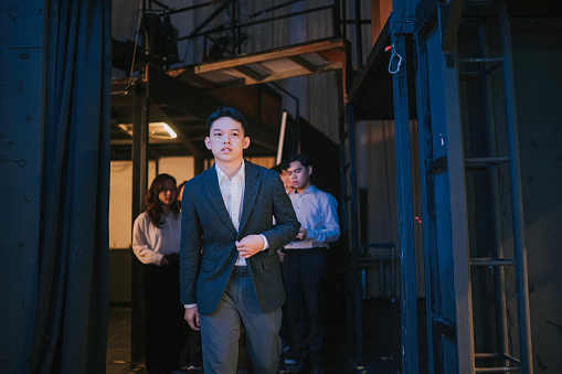 Asian Chinese Pianist artist performer walking from backstage to stage performing