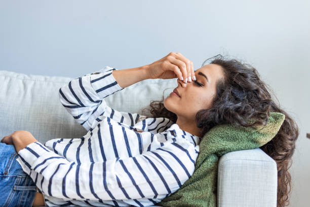 istock Upset depressed young woman lying on couch feeling strong headache migraine 2149649806