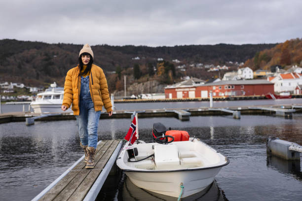 istock Young Woman Walking on Dock by Moored Boat in Norwegian Harbor 2149650701