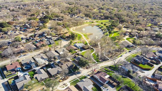 Lakeside residential neighborhood with bare trees wintertime suburbs Dallas Fort Worth metro complex, cul-de-sac dead-end street shapes keyhole, single family houses with swimming pools backyard. USA