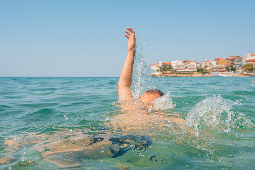 Young man drowning in the sea in Sithonia in Greece.