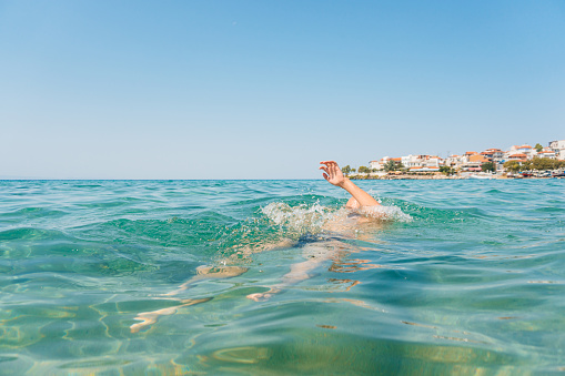 Young man drowning in the sea in Sithonia in Greece.