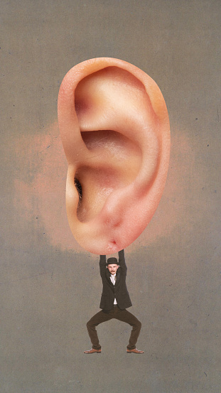 Poster. Contemporary art collage. Young man in retro outfit hanging from giant ear against brown background. Concept of inspiration, surrealism, fashionable, gossips, communication. Pop art.