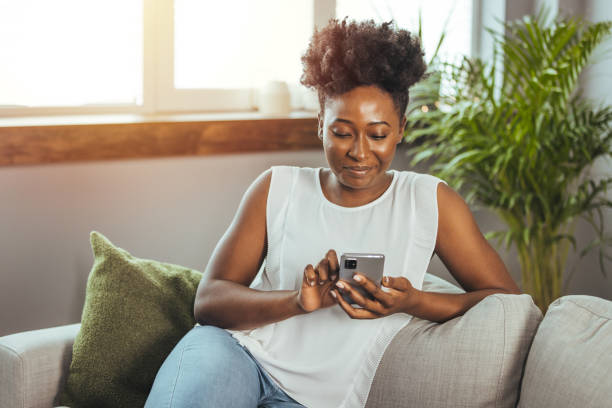 istock Happy woman text messaging on smart phone at home. 2149655358