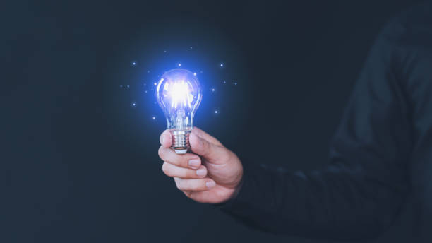 istock Freelancer hand holding illuminated light bulb. Creative idea, new business plan, motivation, innovation, inspiration. Energy saving light bulb. Concept of new ideas with innovation and creativity. 2149656856