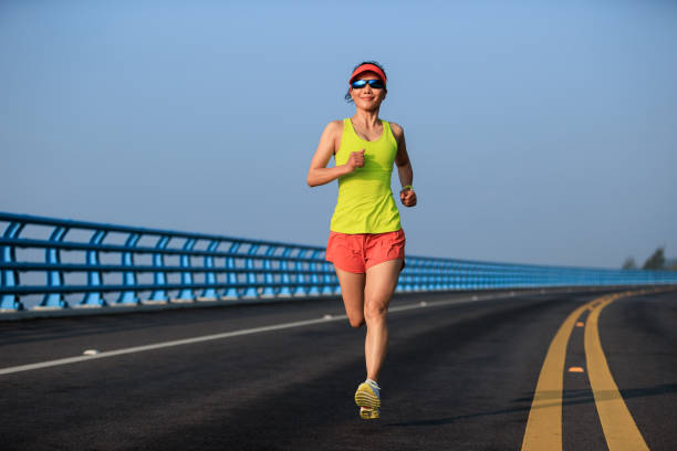 Fitness woman runner running on seaside bridge