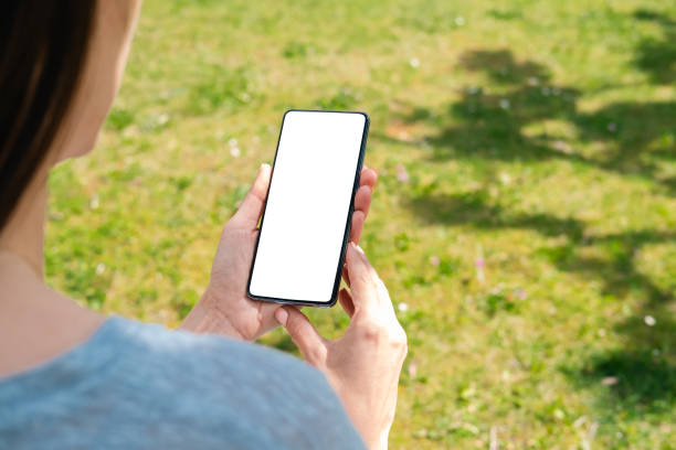 istock A woman looking at a telephone in the park. 2149658731