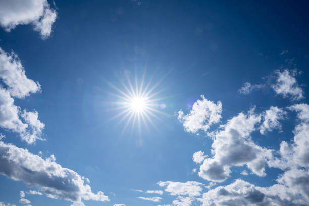 Bright summer sun in the blue sky with white clouds