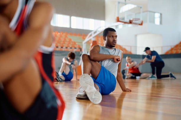 istock Black basketball player stretching on the floor during sports training. 2149659966