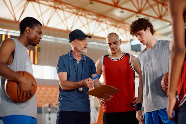 istock Mature coach explaining game strategy to his players during basketball practice. 2149660020