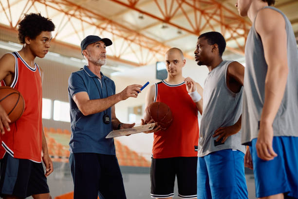 istock Basketball coach discussing about game plan with his players during sports training. 2149660024