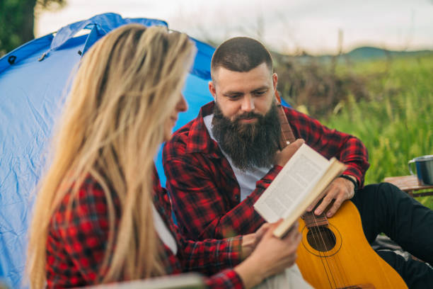 istock Hipster couple enjoying a book on the camping 2149660185