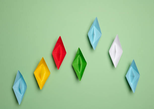istock Multi-colored paper boats move forward, some of them rush forward. Concept of rivalry 2149662974