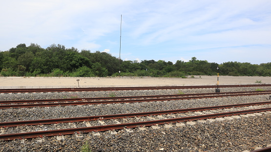 Close-up view of multi-track railroad tracks stretching into the distance against a blue sky background