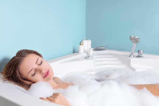 istock Young woman relaxing in bathtub with foam 2149669773