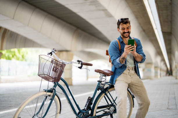 istock Handsome man texting on phone sitting on bike 2149670201