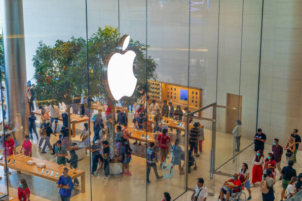 Bangkok, Thailand - 30 December, 2023: Top view on people buyers watching phones in flagship Apple store in Icon Siam shopping mall. Chain of retail stores owned and operated by Apple Inc.
