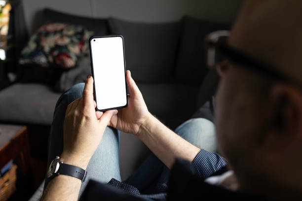 istock man sitting on the sofa at home and using a smartphone 2149674010