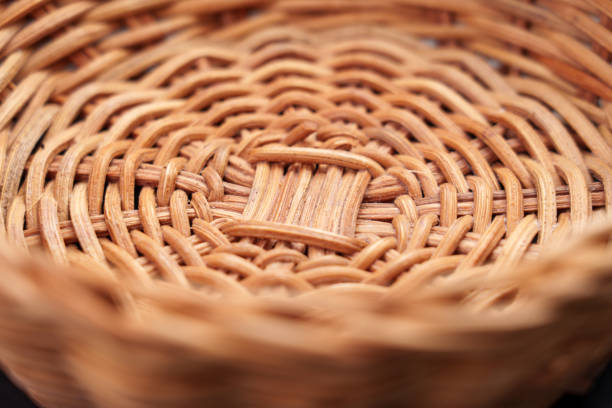 A large collection of handwoven wicker baskets in various shapes and sizes is displayed on the ground at an outdoor market. The natural tones and detailed weaving patterns highlight traditional craftsmanship and rustic charm.