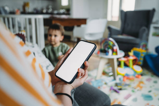 istock A mother is using her mobile phone at home 2149680652