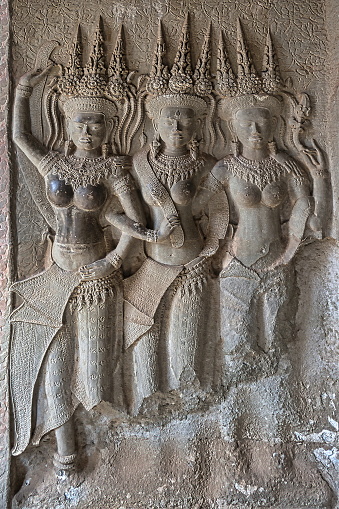 Three Apsaras at Angkor Wat temple. Figures in both Hindu and Buddhist culture,  originally they were a female spirit of the clouds and waters, but, later they play the role of a 