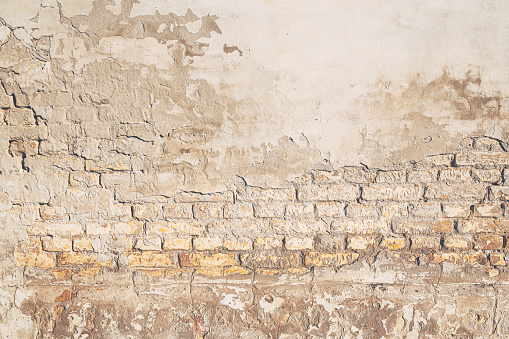 Background of old brickwall, texture of an worn facade made of bricks and mortar as design element
