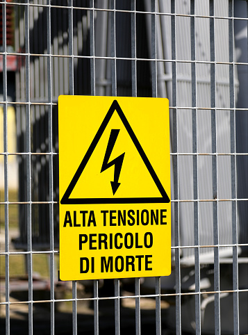 gran señal de peligro de una central eléctrica con la inscripción en italiano PELIGRO DE MUERTE DE ALTA TENSIÓN photo