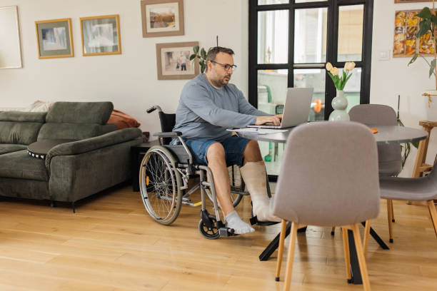istock Man in wheelchair working at table 2149681951