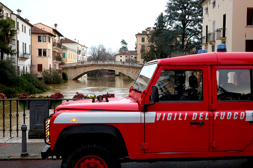 Vicenza, VI, Italy - February 28, 2024: red vehicle of Fireman with text  in italian language during flood on the bridge